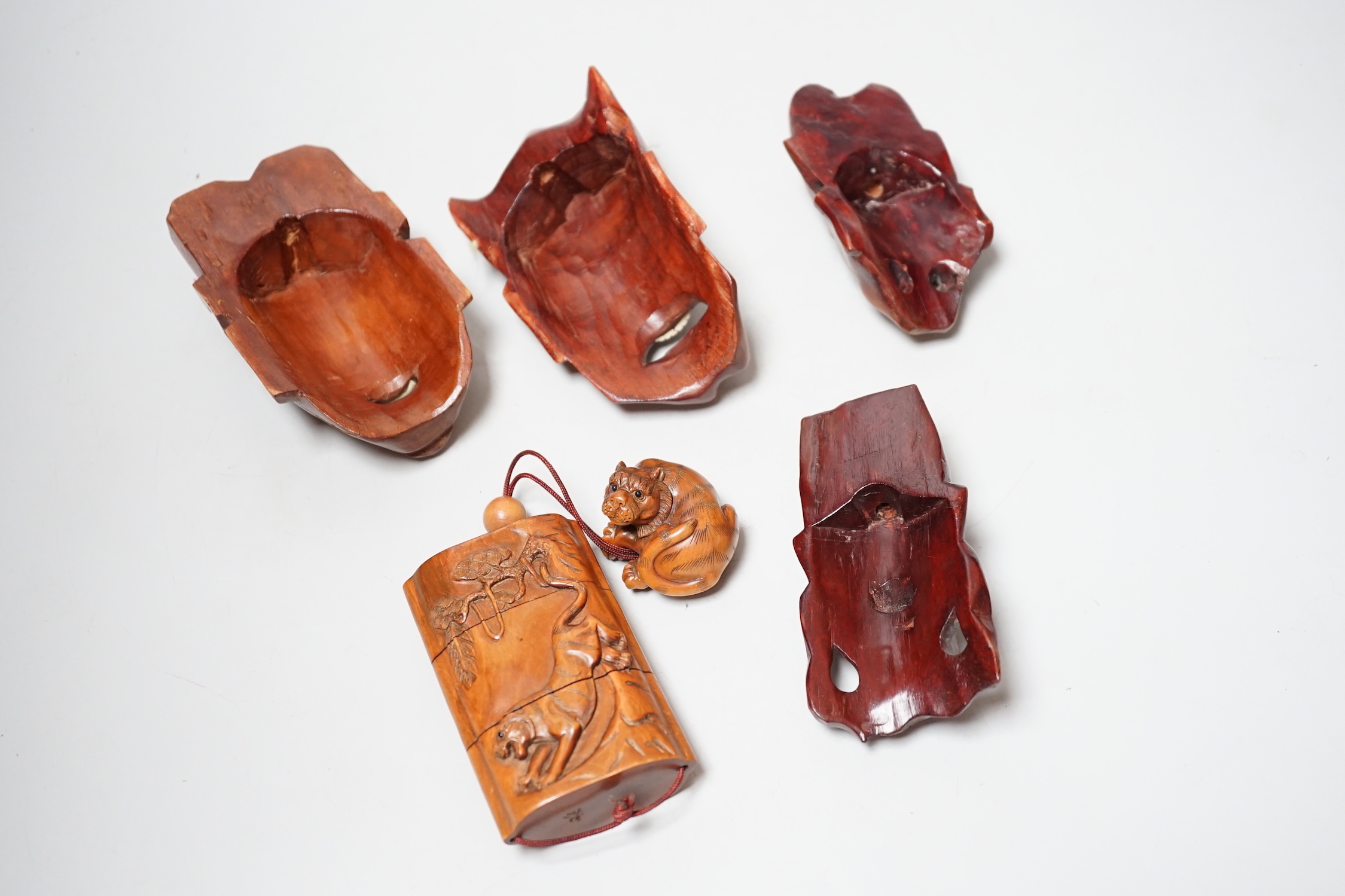 A group of hardwood models of noh masks and a similar inro, 9cm and netsuke